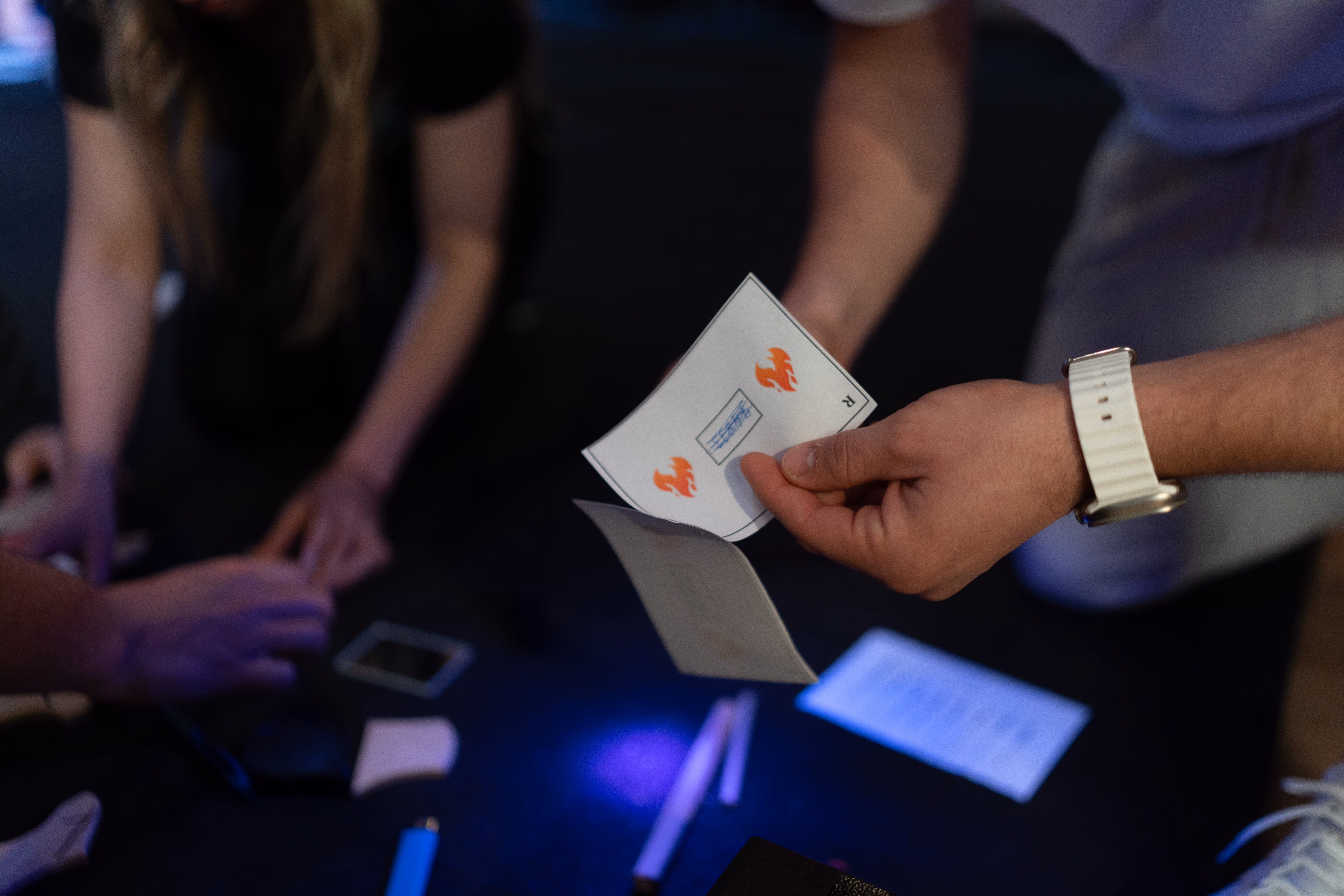 Team übergibt eine Hinweiskarte während eines individuellen Escape Games
